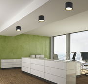 Moderne schwarze Deckenleuchte aus Metall in einem Büro, Perspektive von unten.