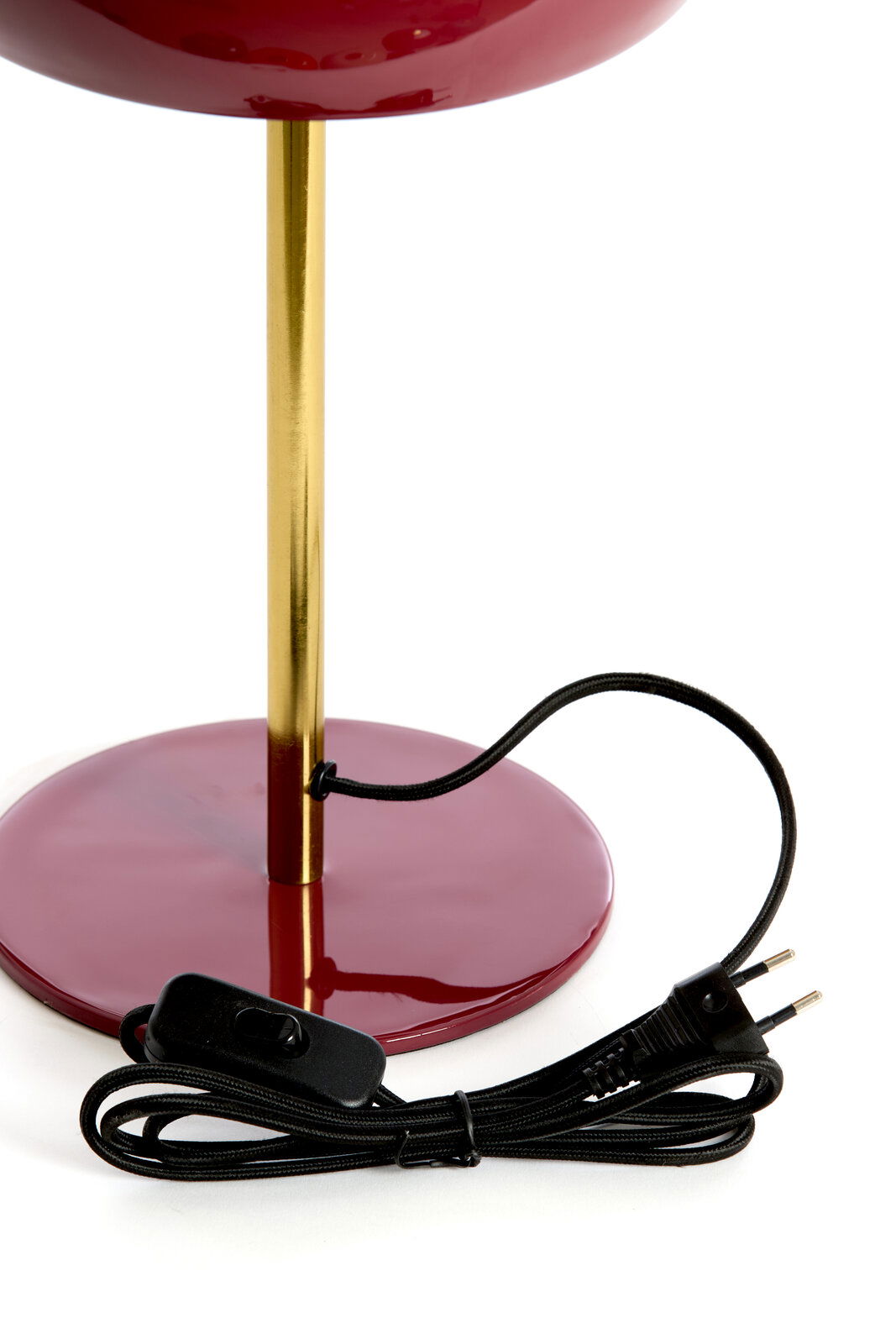 Nahaufnahme der Tischleuchte SURIN mit einem goldenen Ständer und einem roten Sockel, inklusive schwarzem Kabel und Schalter.