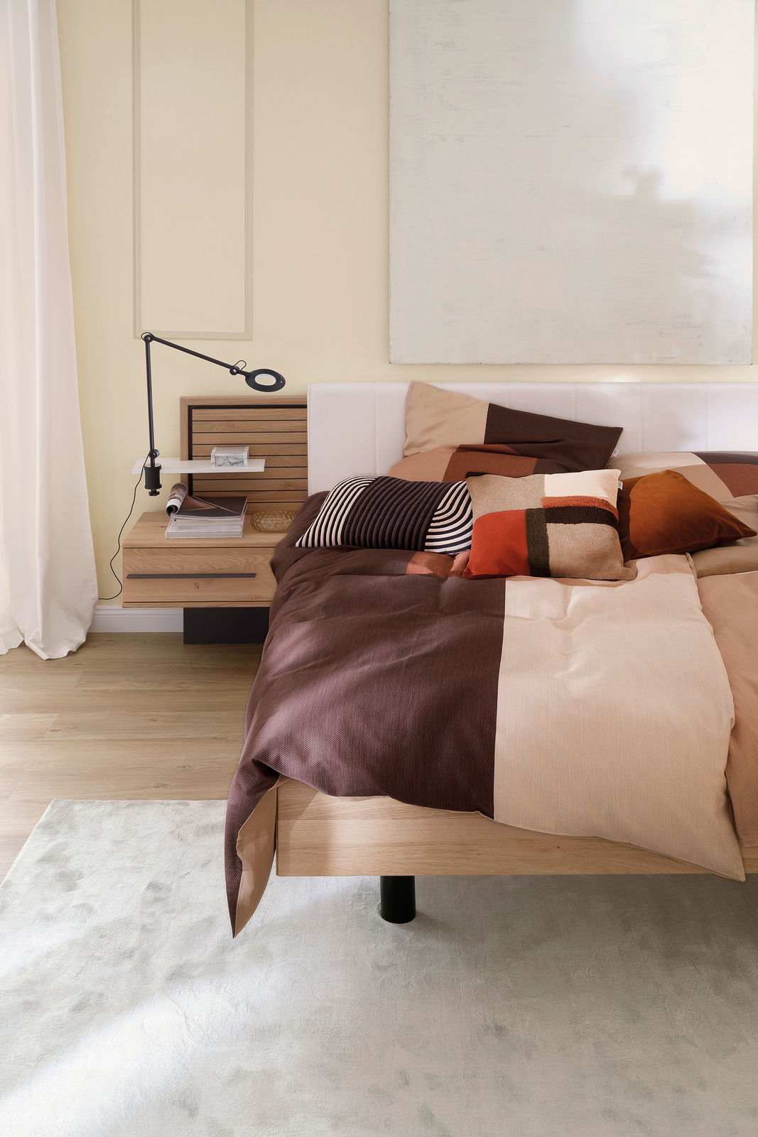 Satin-Bettwäsche 155x220 cm in einem modernen Schlafzimmer, mit einem Patchwork-Design in warmen Erdtönen, aus der Perspektive von der Seite des Bettes.