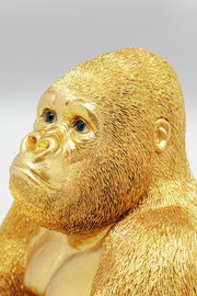 Goldene Gorilla-Dekofigur in Nahaufnahme, die den Kopf leicht zur Seite neigt.
