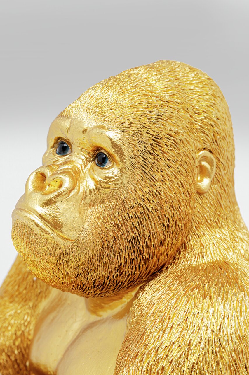 Goldene Gorilla-Dekofigur in Nahaufnahme, die den Kopf leicht zur Seite neigt.