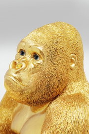 Goldene Gorilla-Dekofigur in Nahaufnahme, die den Kopf leicht zur Seite neigt.