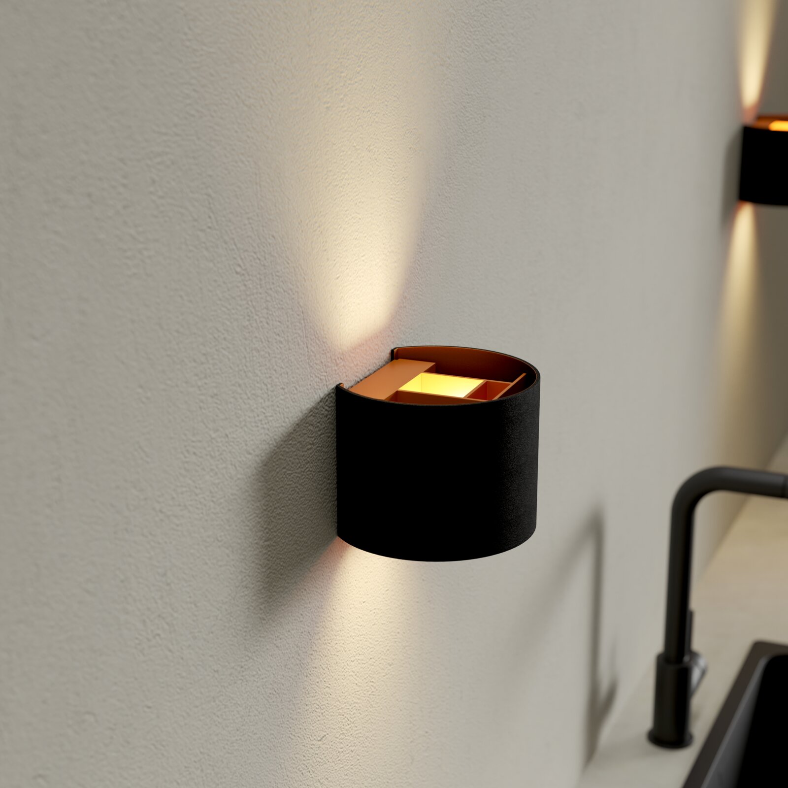 Moderne schwarze Wandlampe mit warmweißem Up-and-Down-Lichtkegel an heller Wand, Nahaufnahme in seitlicher Perspektive (schräg von vorn).