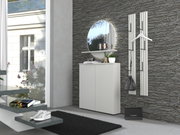 Moderne halinrichting met een witte schoenenkast, een ronde wandspiegel met plank en twee witte wandkapstokken tegen een grijze stenen muur, zijaanzicht