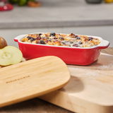 Rote KitchenAid Auflaufform mit Deckel, gefüllt mit einem gebackenen Gericht, aus seitlicher Perspektive fotografiert.