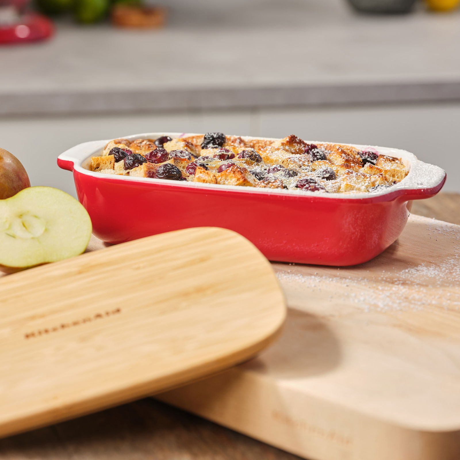 KitchenAid Auflaufform Rote KitchenAid Auflaufform mit Deckel, gefüllt mit einem gebackenen Gericht, aus seitlicher Perspektive fotografiert.
