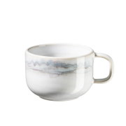 Weiße Keramik-Kaffeetasse mit rundem Henkel und dezenter blau-grauer Verlaufsglasur, freigestellt auf weißem Hintergrund, Seitenansicht leicht von oben