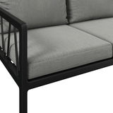 Nahaufnahme einer modernen Gartenbank mit grauen Kissen und schwarzem Metallrahmen, seitliche Perspektive.