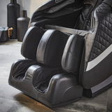 Nahaufnahme eines luxuriösen Massagesessels in schwarzem Leder mit Fuß- und Beinmassagefunktion, seitliche Perspektive.