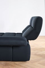 Seitenansicht einer modernen, dunkelgrauen Eckgarnitur mit verstellbarer Rückenlehne auf einem Holzboden.