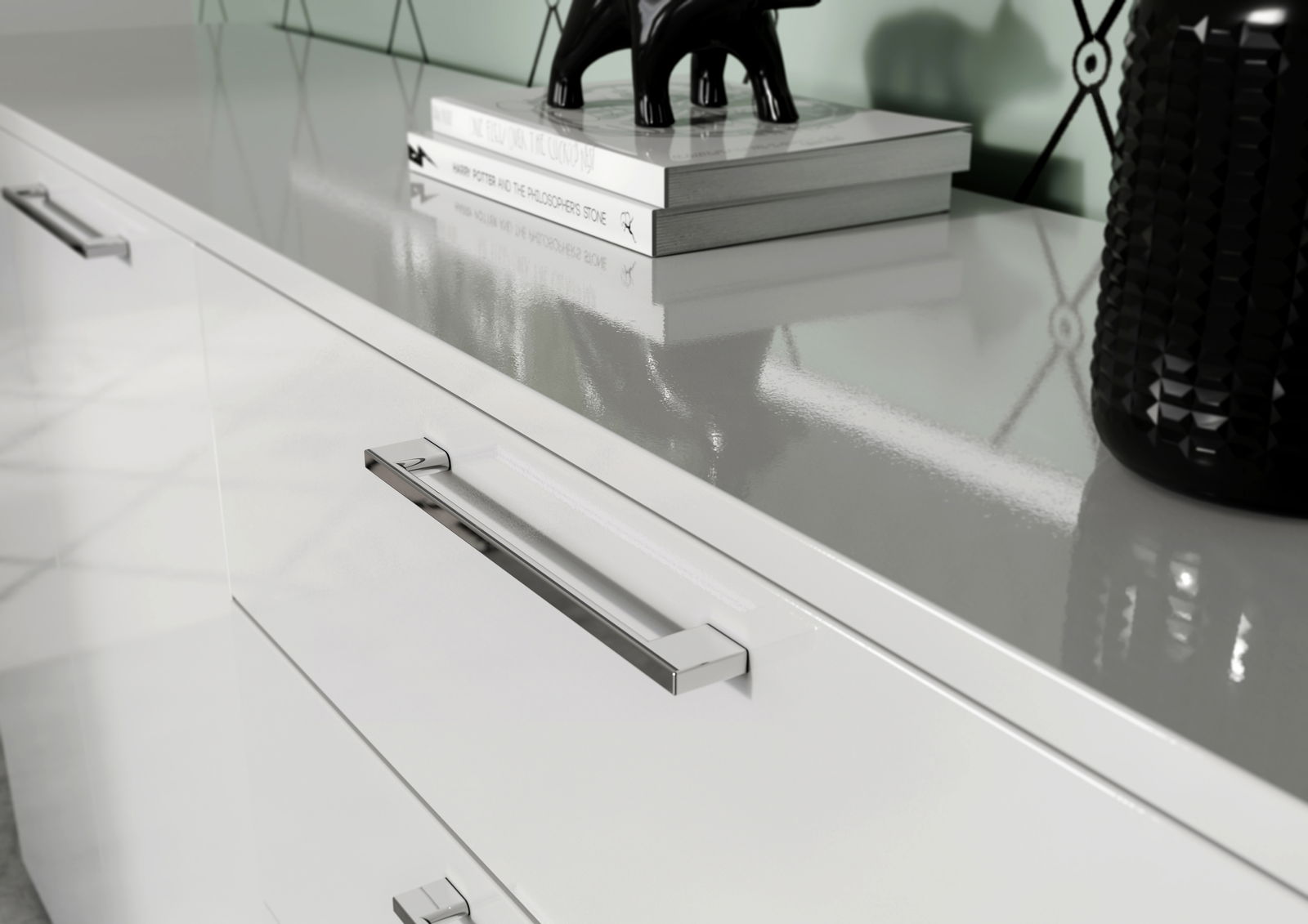 Nahaufnahme einer modernen weißen Kommode mit glänzender Oberfläche, silbernen Griffen und dekorativen Elementen auf der Oberseite, seitliche Perspektive.