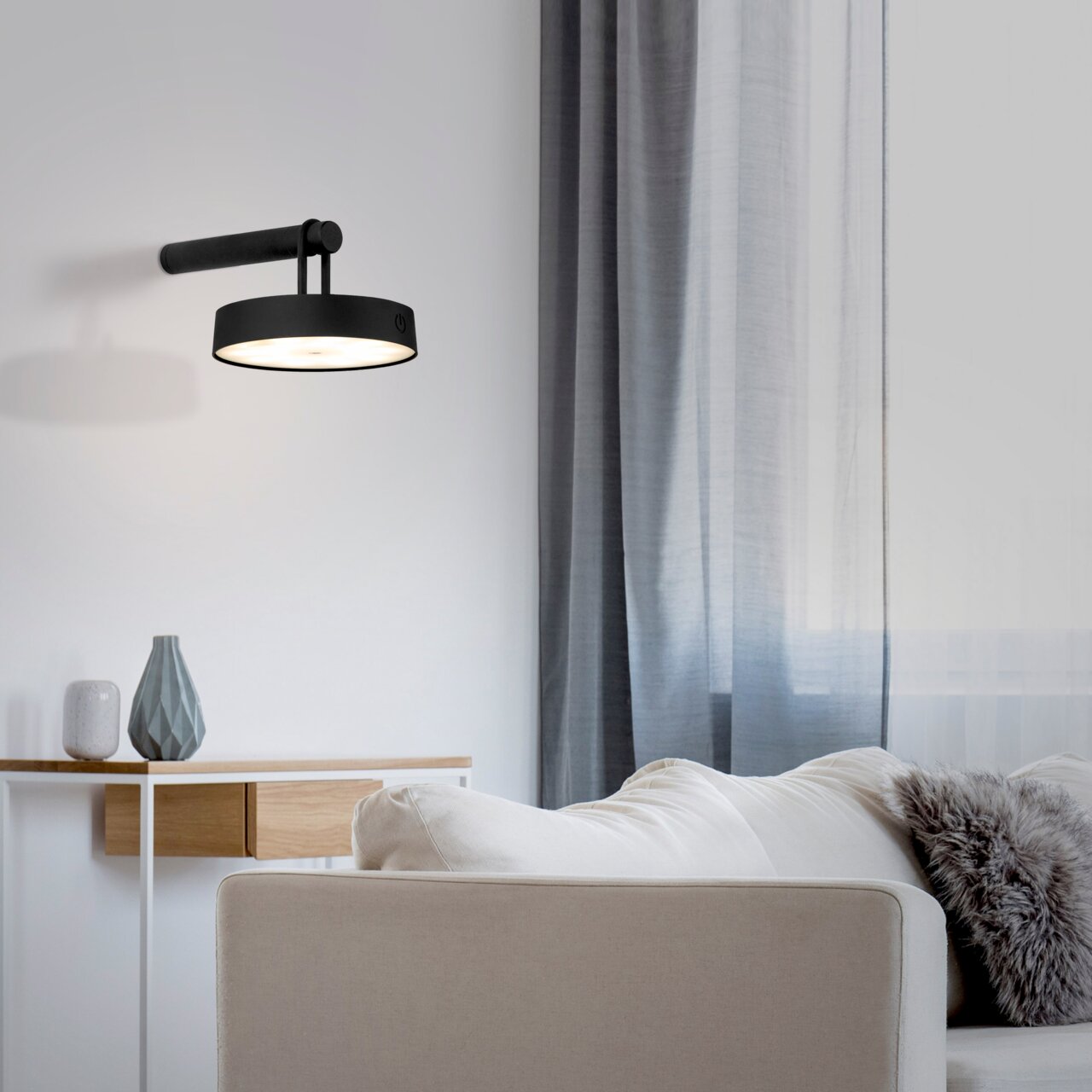 Moderne zwarte wandlamp ARMA in een stijlvolle woonkamer, zijaanzicht