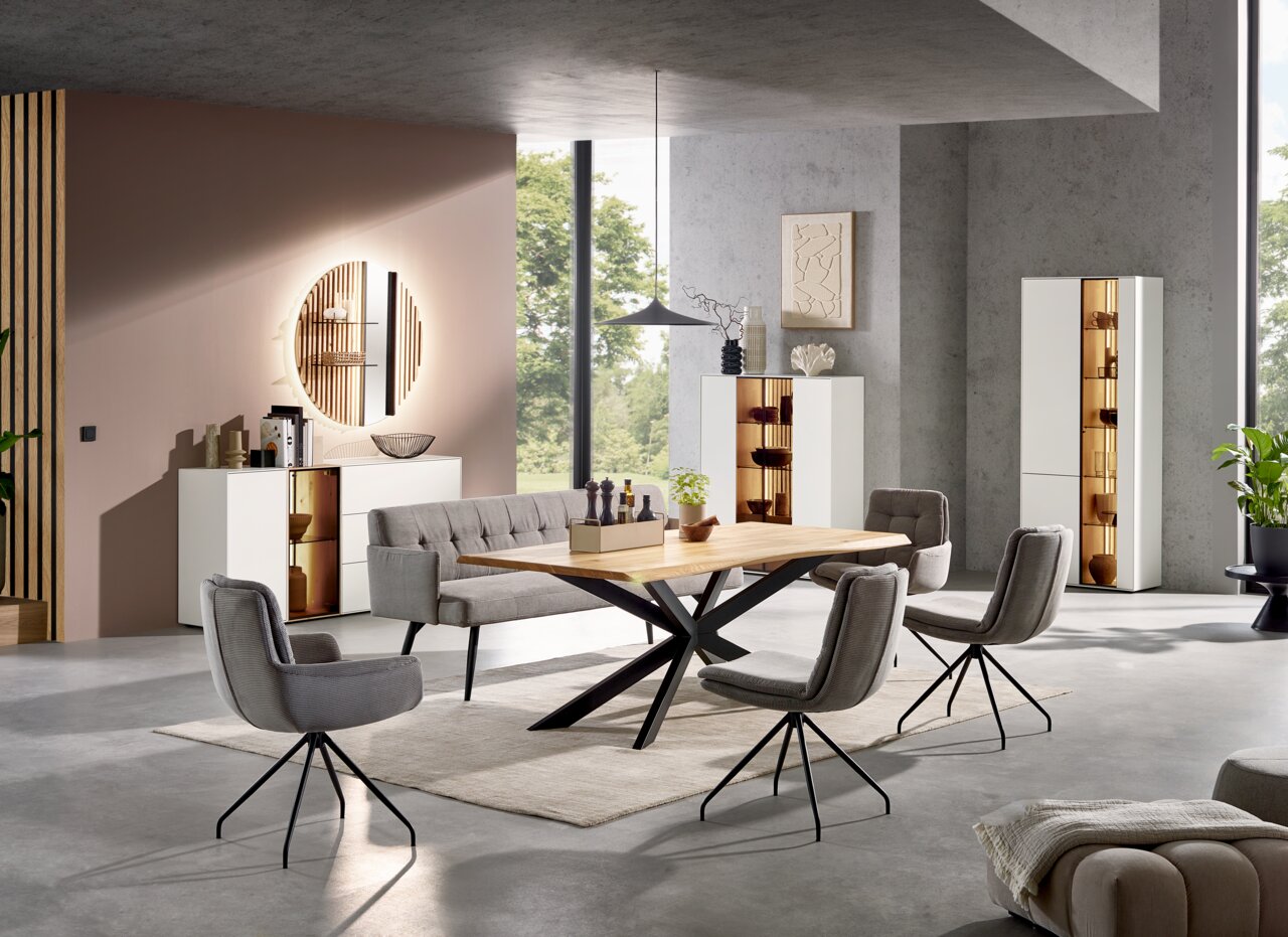 Moderne Wohnzimmermöbel mit Esstisch und Vitrinen in einem stilvollen, hellen Raum. Perspektive von vorne.