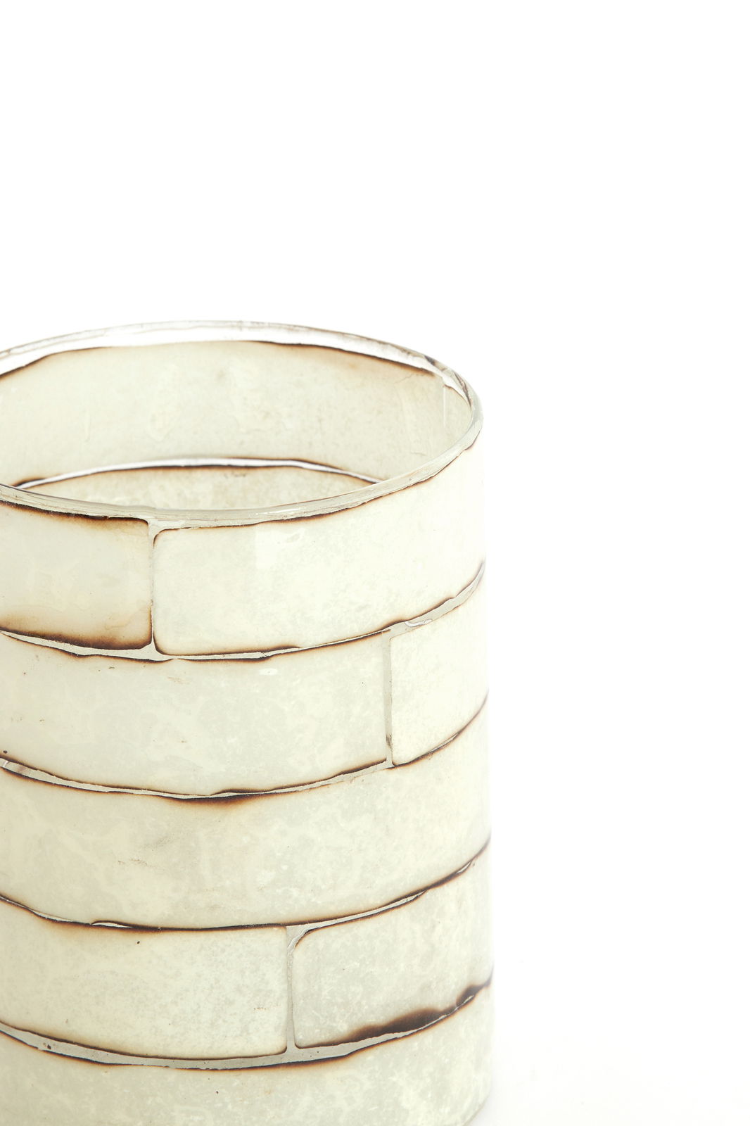 Nahaufnahme eines dekorativen Teelichthalters mit einem gestapelten, rechteckigen Design in sanften Weiß- und Beigetönen.