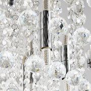 Nahaufnahme einer Deckenleuchte mit funkelnden Kristallanhängern und LED-Lampen, von unten betrachtet.