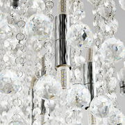 Nahaufnahme einer Deckenleuchte mit funkelnden Kristallanhängern und LED-Lampen, von unten betrachtet.