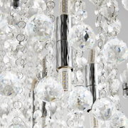 Nahaufnahme einer Deckenleuchte mit funkelnden Kristallanhängern und LED-Lampen, von unten betrachtet.