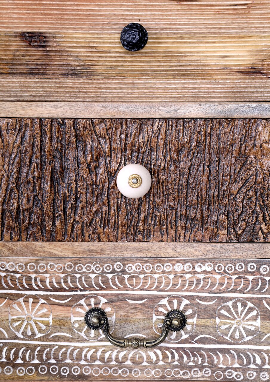 Detailansicht einer Kommodenfront mit verschiedenen Holzstrukturen und dekorativen Knöpfen.