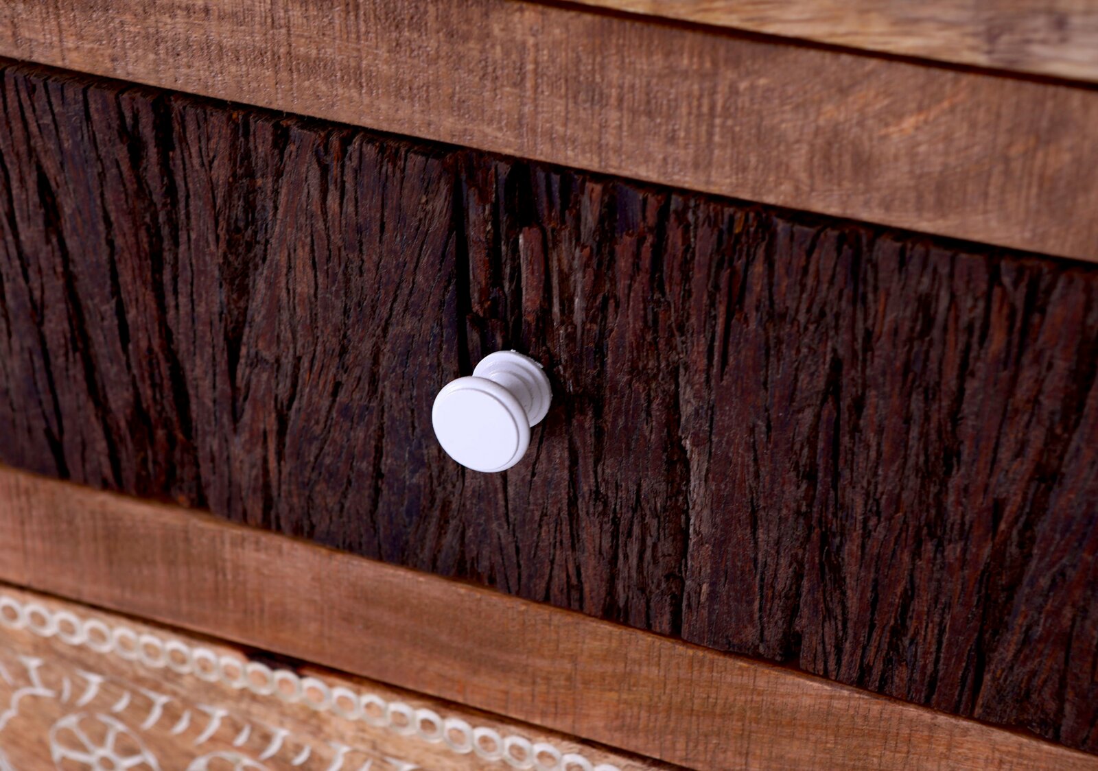 Close-up van een rustieke houten lade met een witte knop, gezien vanaf de zijkant