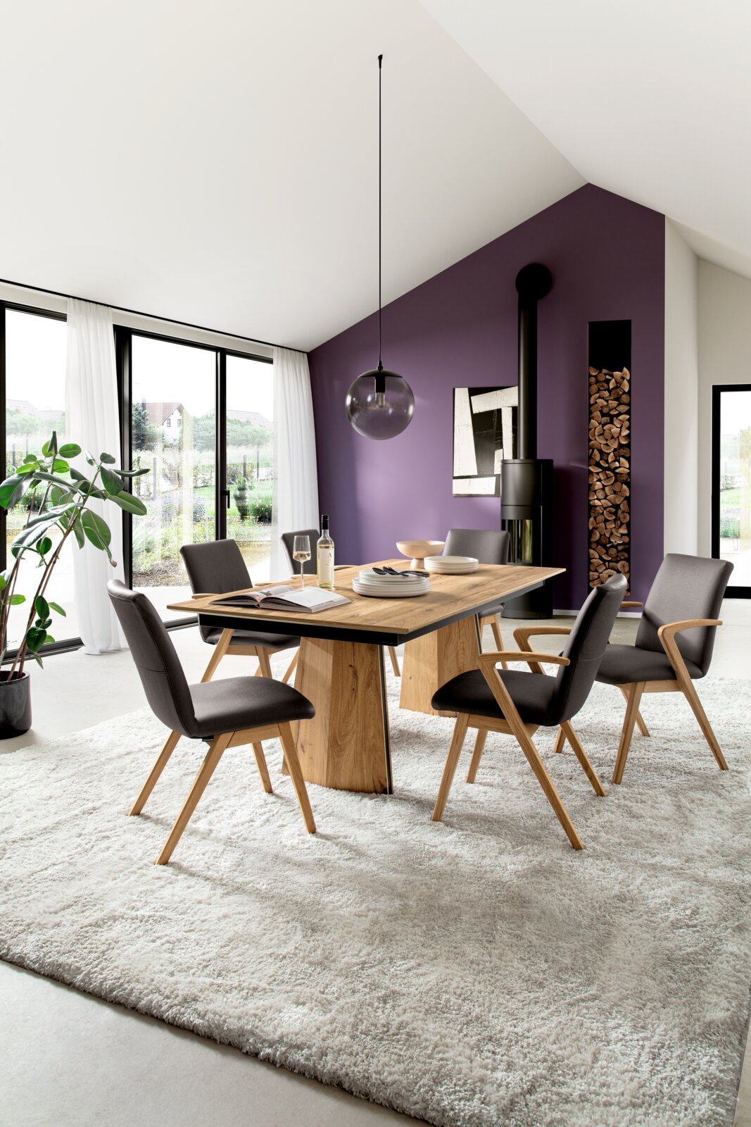 Venjakob Eettafel ET697 HYLO Moderne eethoek met rechthoekige houten eettafel en vier grijze stoelen op licht vloerkleed, met glazen hanglamp en paarse accentmuur op de achtergrond, gefotografeerd in schuin vooraanzicht