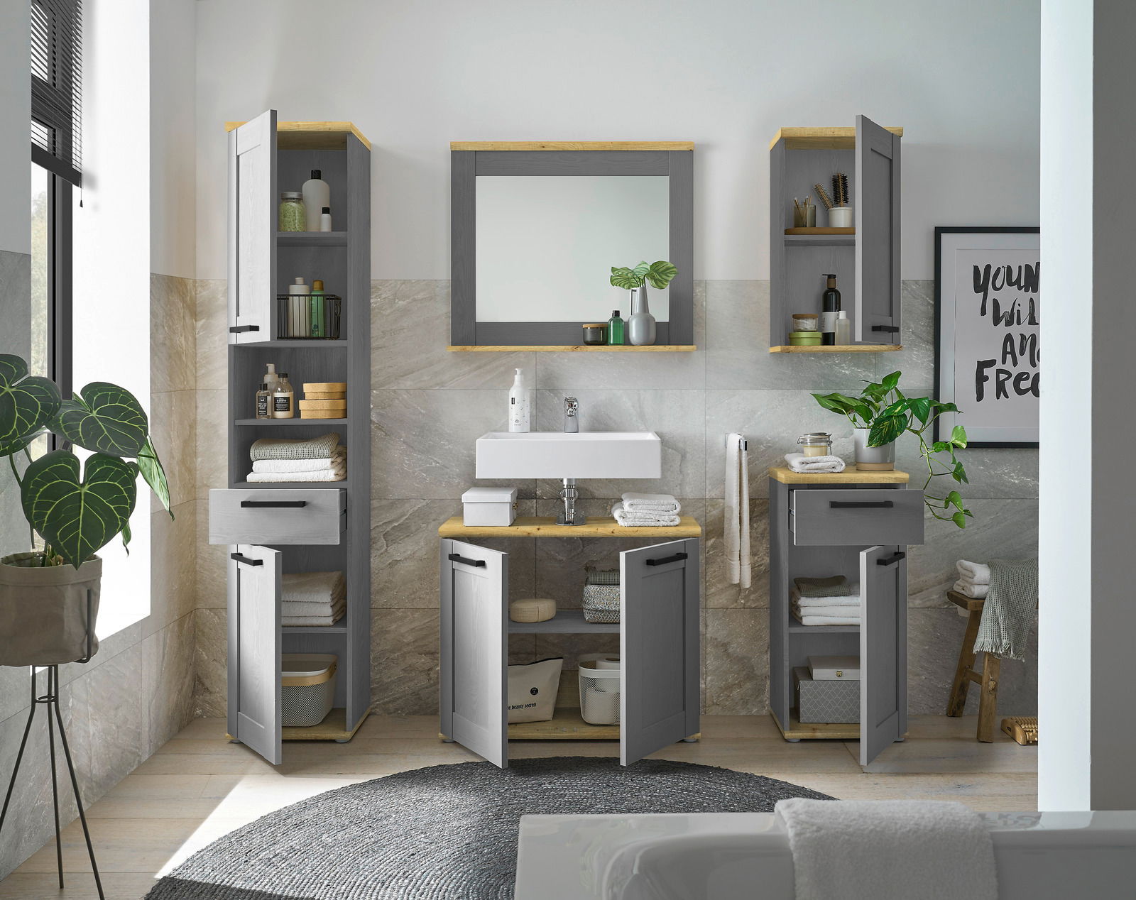 Moderner grauer Waschbeckenunterschrank mit Holzdetails, frontal fotografiert, umgeben von passenden Schränken und Dekorationen in einem stilvollen Badezimmer.