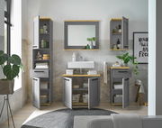 Moderner grauer Waschbeckenunterschrank mit Holzdetails, frontal fotografiert, umgeben von passenden Schränken und Dekorationen in einem stilvollen Badezimmer.