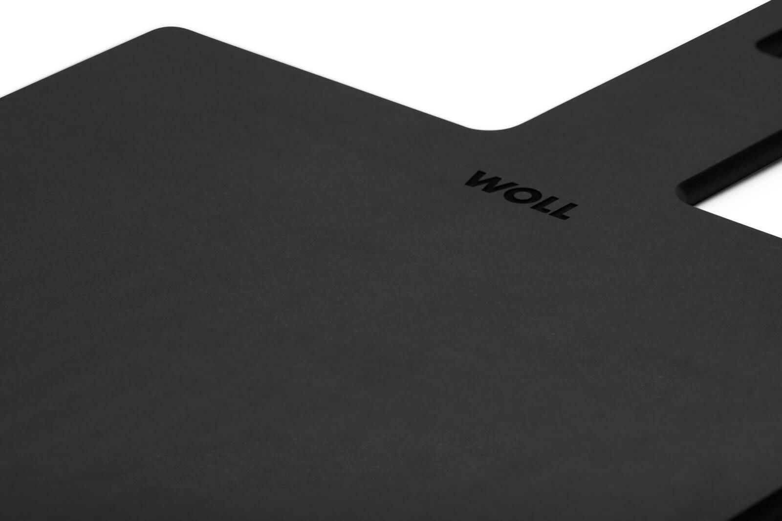 Schwarzes Schneidebrett mit der Aufschrift 'WOLL', perspektivisch von oben fotografiert.