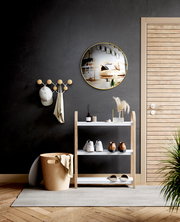 Moderne Wandgarderobe mit runden Haken, an der eine Mütze und ein Tuch hängen, in einem stilvoll eingerichteten Raum mit dunkler Wand und Holzdetails, aus frontaler Perspektive.