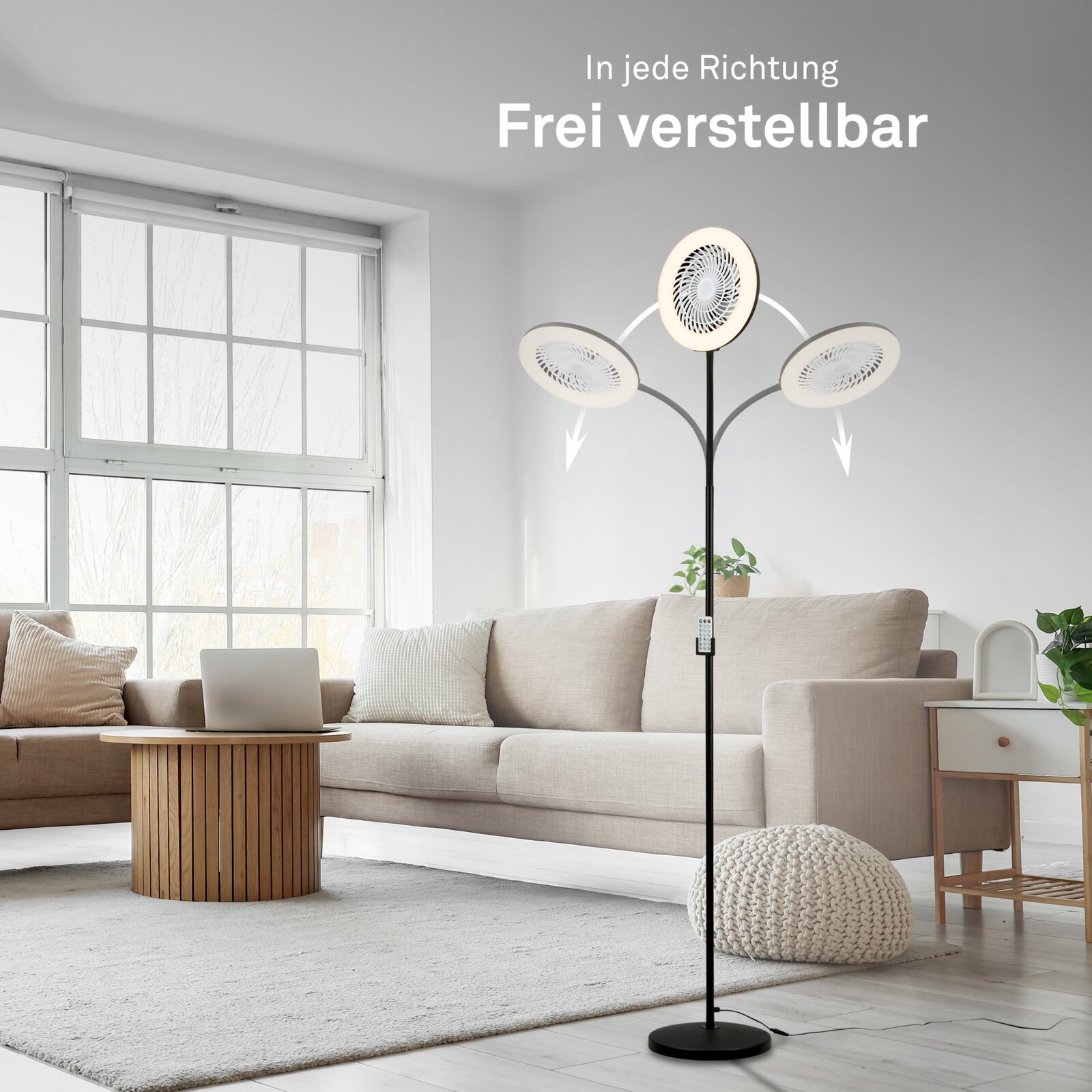 Schwarzer Standventilator mit drei frei verstellbaren Ventilatorköpfen im Wohnzimmer neben beigem Sofa, frontale Perspektive auf das Produkt.