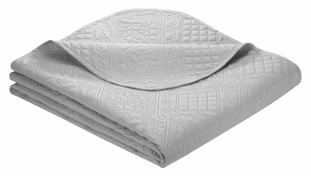 IBENA Decke NANCY Graue Tagesdecke Nancy 220x250cm mit gestepptem Muster, gefaltet und aus einer schrägen Perspektive fotografiert.