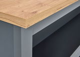 Nahaufnahme einer Kücheninsel mit einer Holzarbeitsplatte und grauer Struktur, Perspektive von der Seite.
