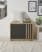 Garderobenbank aus Holz mit schwarzer Front, dekoriert mit einem weißen Kissen und Sonnenbrille, seitliche Perspektive