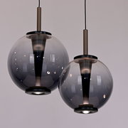 Zwei moderne LED-Pendelleuchten mit rauchgrauen Glaskugeln, von unten betrachtet.