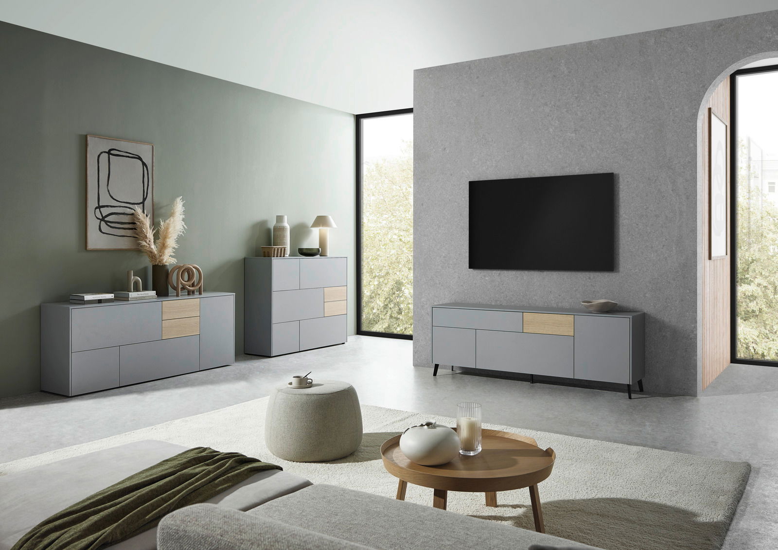 Modernes Wohnzimmer mit grauem TV-Lowboard, Sideboard und Highboard in minimalistischer Einrichtung, seitliche Perspektive