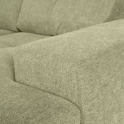 Nahaufnahme einer grünen Sofaecke mit texturierter Stoffoberfläche, Perspektive von der Seite.