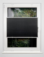 Schwarzes Plissee am Fenster, halb heruntergelassen, mit Blick auf einen Garten im Hintergrund.