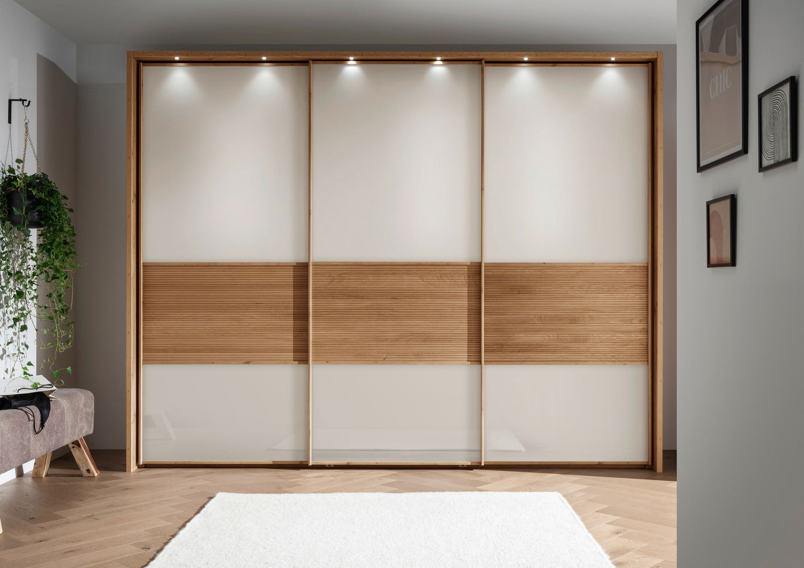 Moderner dreitüriger Schwebetürenschrank mit Holz- und Glaselementen, frontal fotografiert in einem stilvoll eingerichteten Raum.