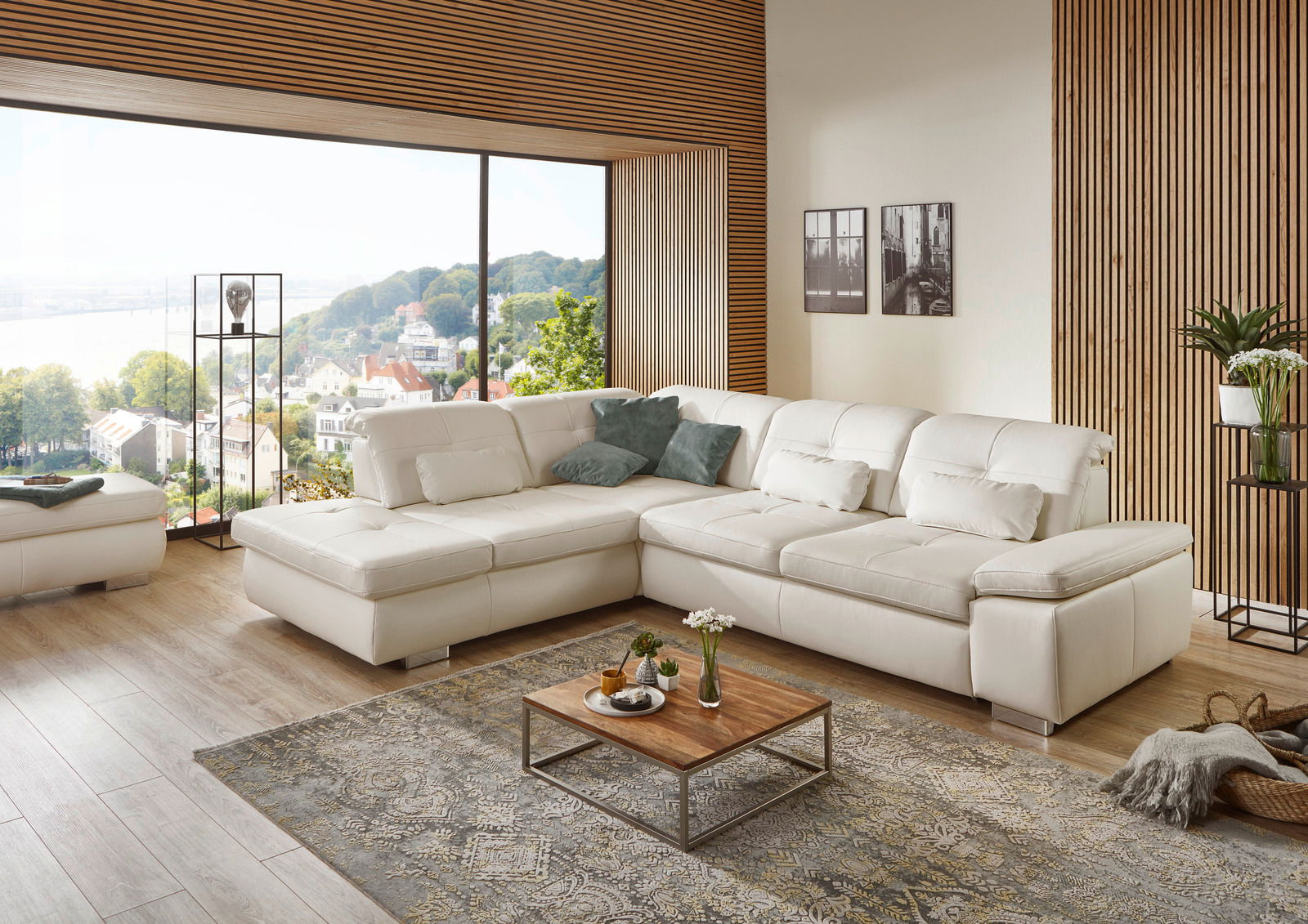 Eckgarnitur in einem modernen Wohnzimmer mit großen Fenstern und Holzwänden, aus der Perspektive von vorne rechts betrachtet.