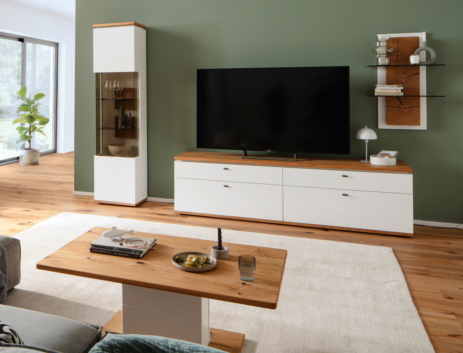 Moderner Couchtisch mit Holzplatte und weißem Sockel in einem stilvoll eingerichteten Wohnzimmer, seitliche Perspektive.