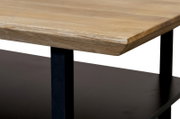 Close-up van een salontafel met een houten blad en een zwart metalen onderstel, gezien vanaf de zijkant.
