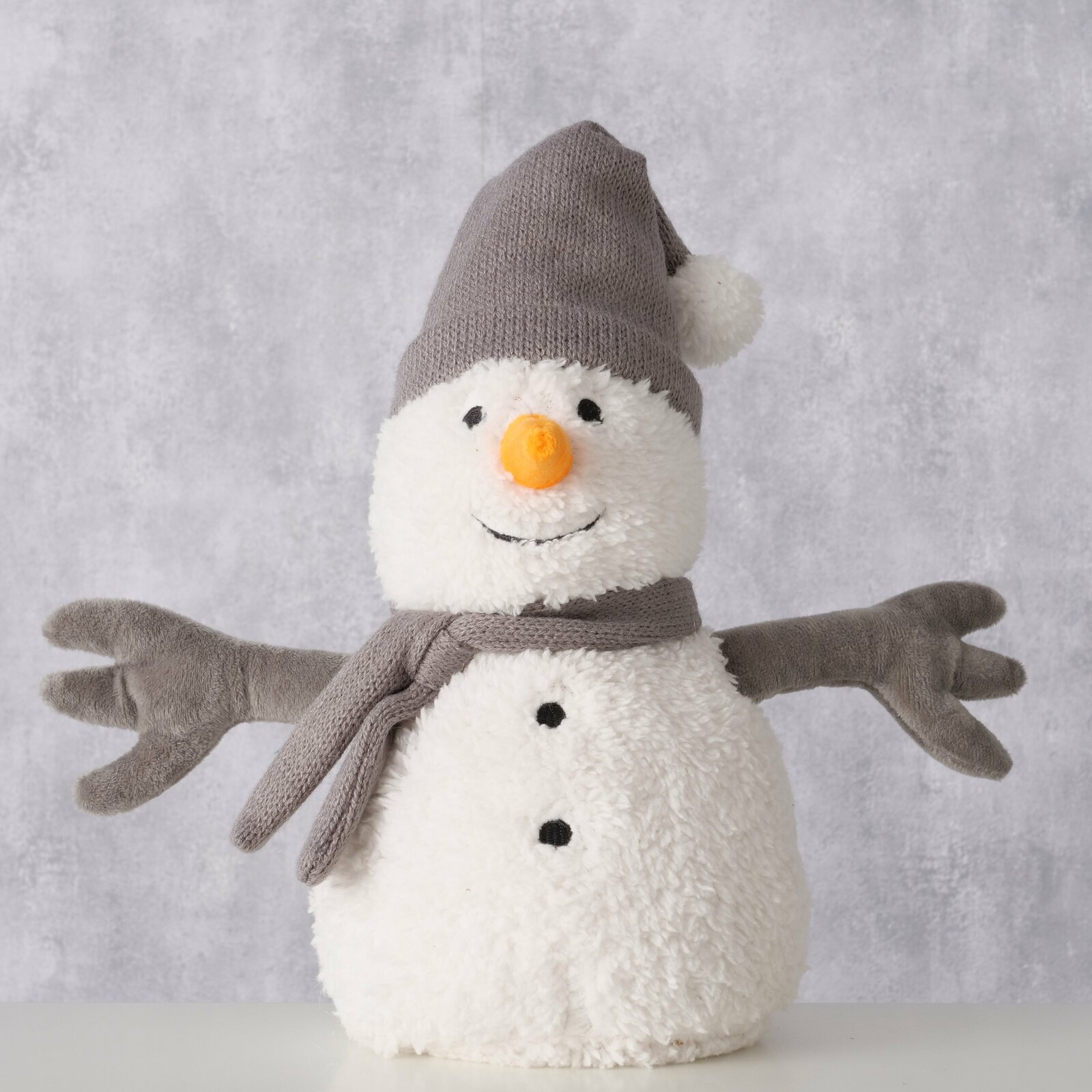 Türstopper in Form eines Schneemanns mit grauer Mütze und Schal, frontal fotografiert.