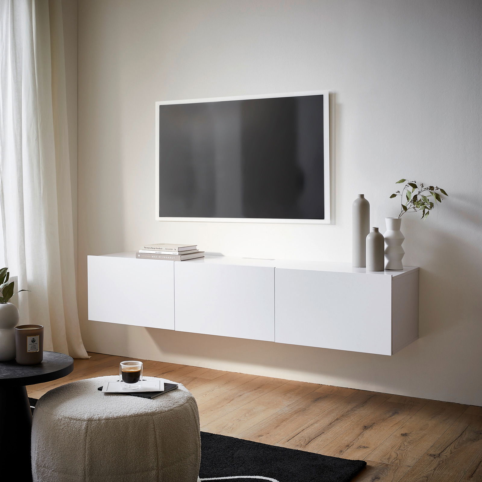 Modernes weißes TV-Hängelowboard in einem stilvollen Wohnzimmer, seitliche Perspektive