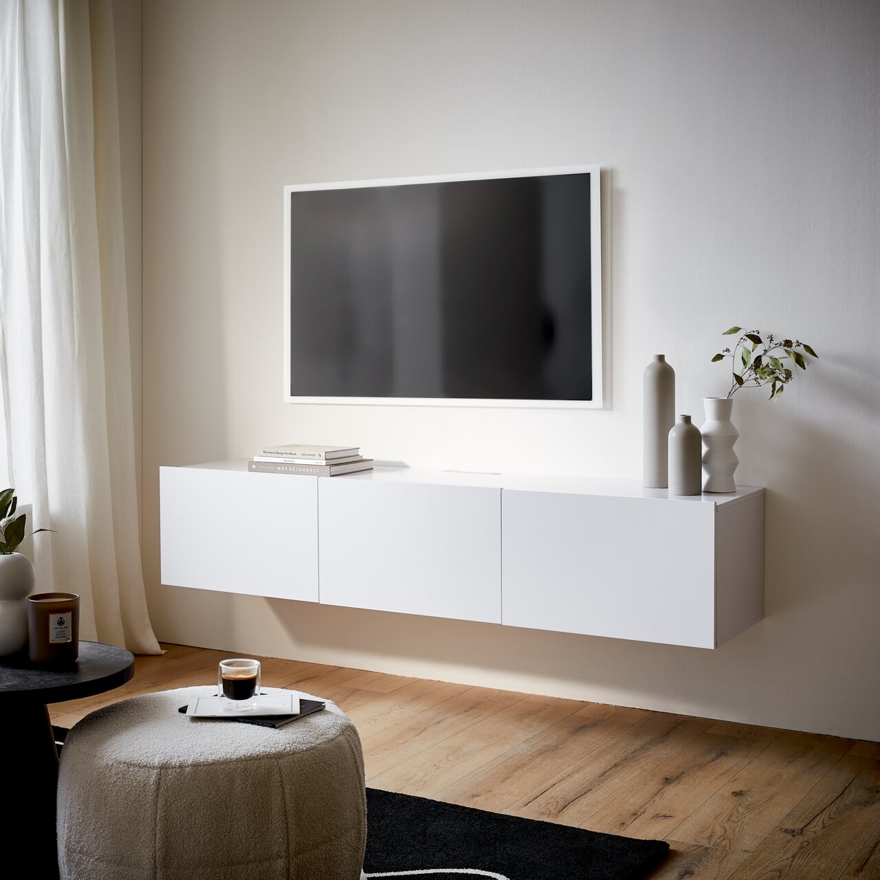 Modernes weißes TV-Hängelowboard in einem stilvollen Wohnzimmer, seitliche Perspektive