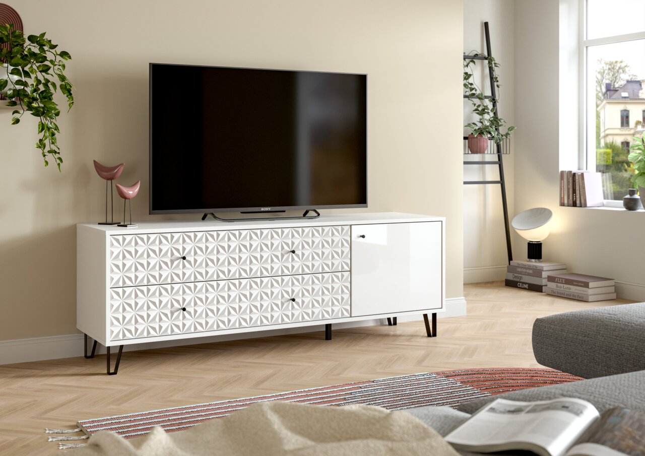 MID.YOU TV-Lowboard PRISMA Weißes TV-Lowboard mit geometrisch strukturierter Front, Schubladen und Tür auf schwarzen Metallfüßen, mit Fernseher darauf, in moderner Wohnzimmerszene aus frontaler leicht seitlicher Perspektive.