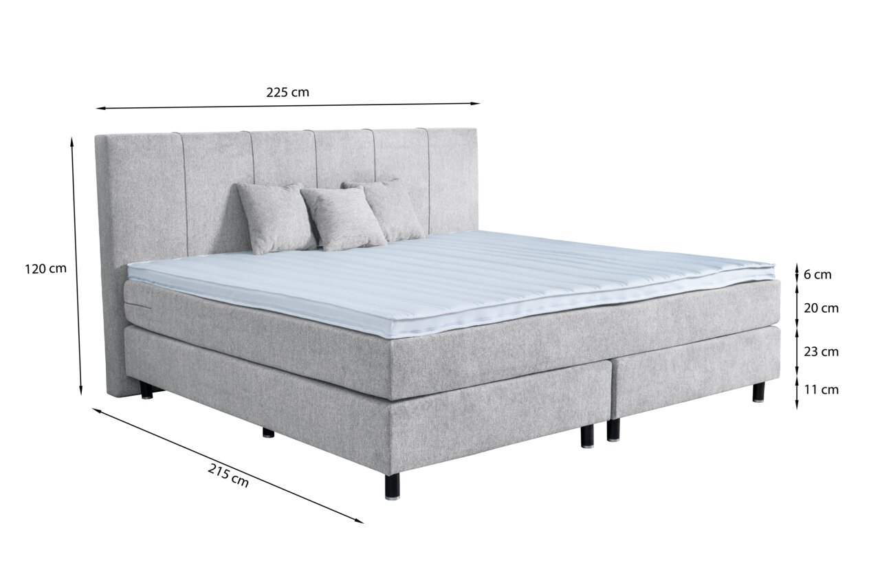 Graues Boxspringbett mit Kopfteil, drei Kissen und blauer Matratzenauflage, seitliche Perspektive