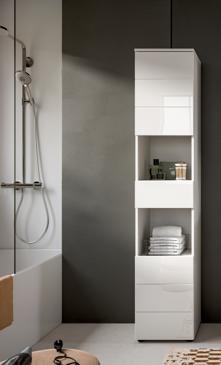 Moderner weißer Hochschrank im Badezimmer, frontal betrachtet, mit offenen Fächern für Handtücher und Pflegeprodukte.