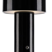 Nahaufnahme einer schwarzen Akku-Tischleuchte AGNES mit glänzendem Finish, seitliche Perspektive.