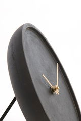 Nahaufnahme einer modernen, minimalistischen Uhr mit schwarzem Zifferblatt und goldenen Zeigern, seitliche Perspektive.