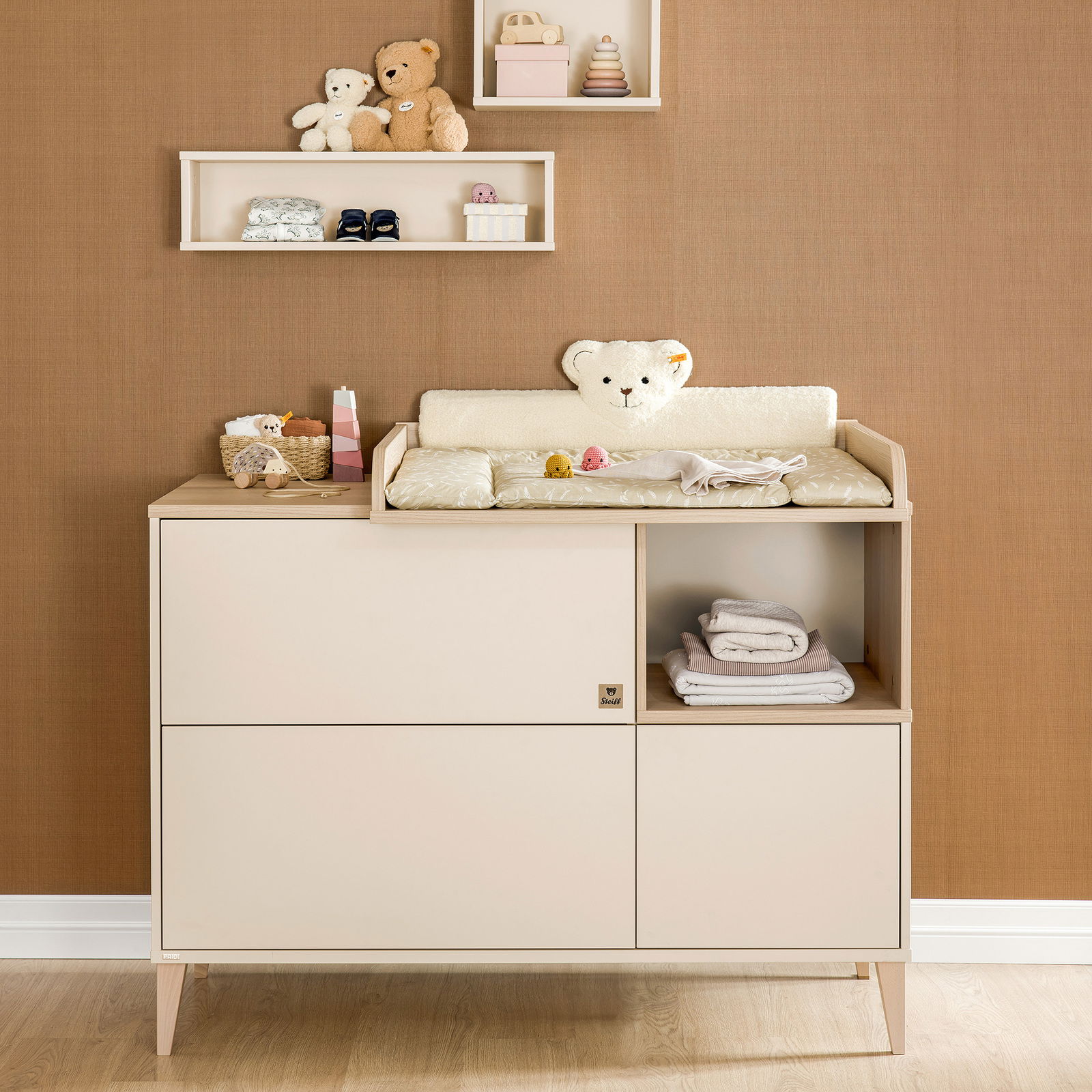 Kommode Paidi MILA&BEN in einem Kinderzimmer, frontal fotografiert. Die Kommode ist mit einem Wickelaufsatz ausgestattet und zeigt weiche Stofftiere und Babyutensilien auf der Ablage.