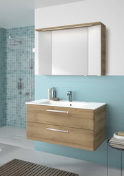 Moderner Badblock mit Holzoptik und zwei Schubladen, kombiniert mit einem weißen Waschbecken und einem Spiegel, aus der Frontalperspektive fotografiert.